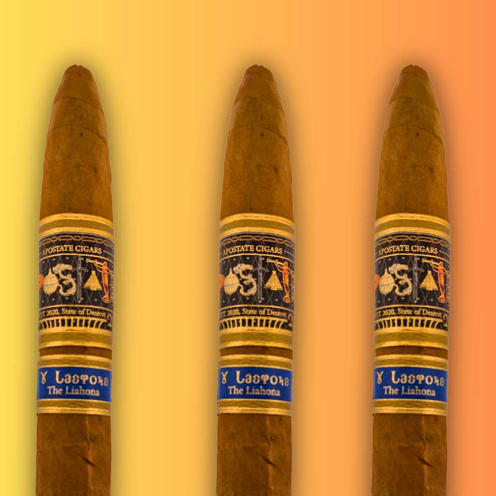 Open box of The Liahona cigars by Apostate, featuring sleek gold branding and neatly arranged cigars.